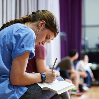 Participant writing on a notebook in a classroom